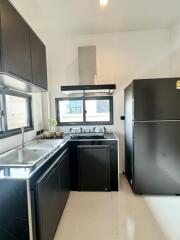 Modern kitchen with black cabinets and stainless steel appliances