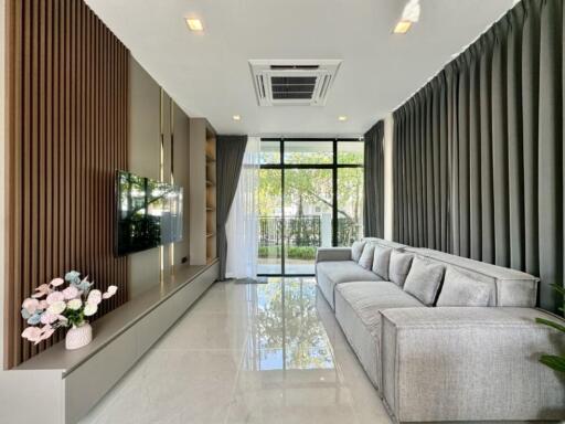 Modern living room with large sofa and wall-mounted TV