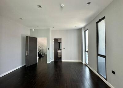 spacious living area with dark wooden flooring and large windows