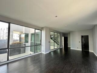 Modern living area with large windows and dark hardwood floors