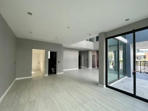 Spacious and modern living area with large windows and light-colored flooring