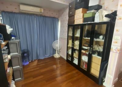 Bedroom with wooden flooring and storage units