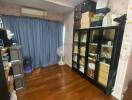 Bedroom with wooden flooring and storage units