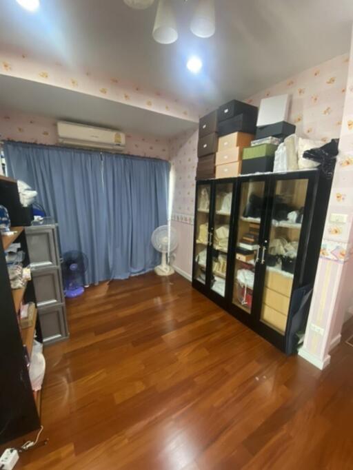 Bedroom with wooden flooring and storage units