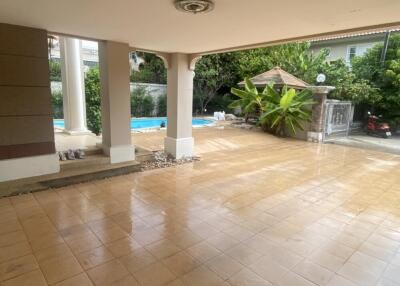 Covered patio area with view of garden and swimming pool