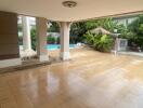 Covered patio area with view of garden and swimming pool