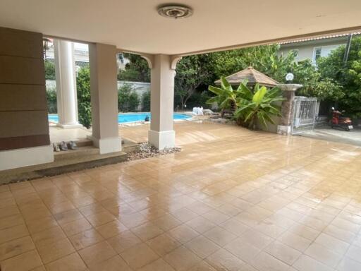 Covered patio area with view of garden and swimming pool