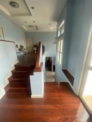 Staircase with wooden floors and large windows