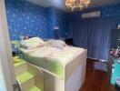 Well-lit bedroom with a loft bed and vibrant blue wallpaper