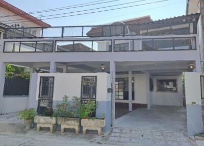 Front view of a residential house with a spacious covered parking area