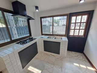 Modern kitchen with large windows and tiled countertops