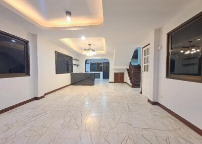 Spacious open-plan living area with modern lighting and tiled floor