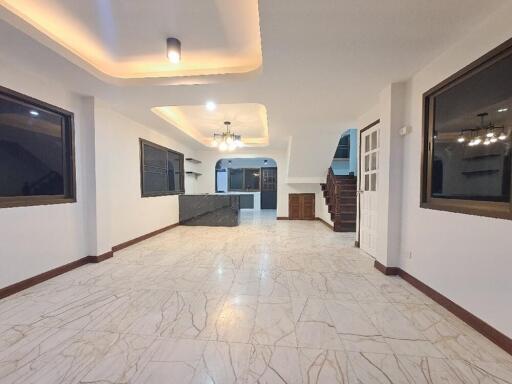 Spacious open-plan living area with modern lighting and tiled floor