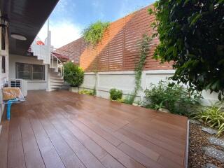 Spacious outdoor patio with wooden decking and garden