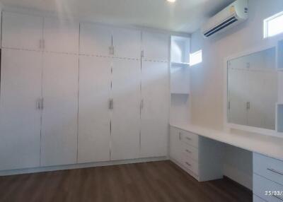 Spacious bedroom with ample built-in storage and vanity area