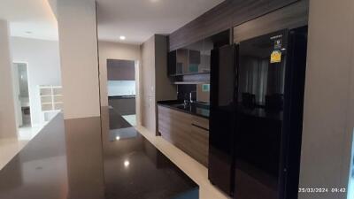 Modern kitchen with sleek black refrigerator and built-in cabinets