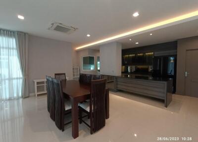 Modern kitchen and dining area with table and chairs, and ample lighting