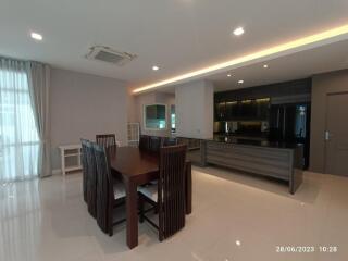 Modern kitchen and dining area with table and chairs, and ample lighting