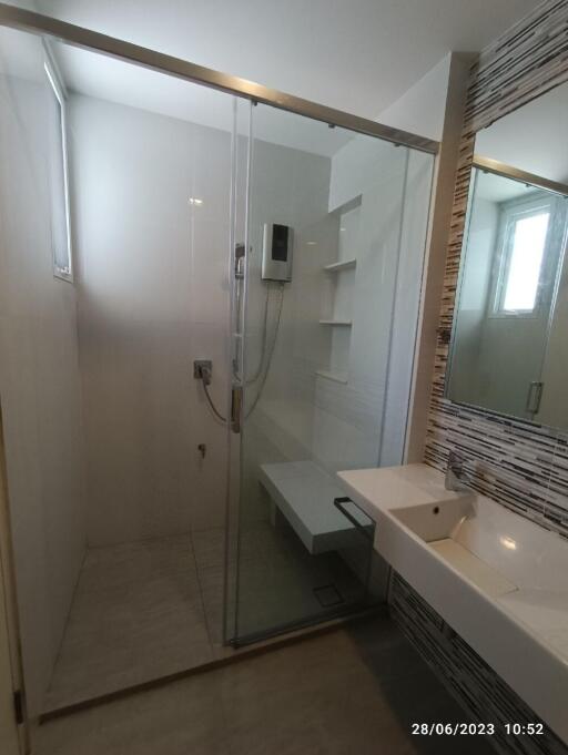 Modern bathroom with glass-enclosed shower and ample natural light