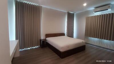 Spacious bedroom with bed, nightstand, and air conditioning
