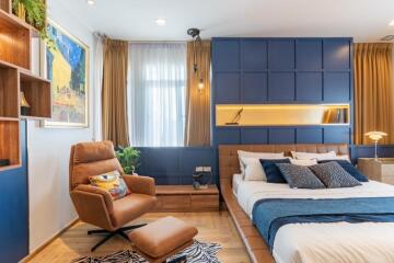 Modern bedroom with blue accent wall and cozy decor