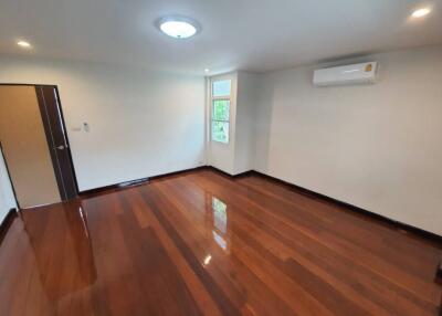 Spacious living room with shiny wooden floors and air conditioning