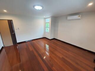 Spacious living room with shiny wooden floors and air conditioning
