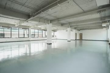 Spacious empty room with large windows and polished floor