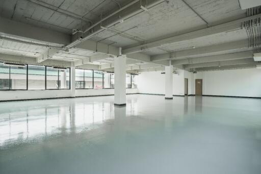 Spacious empty room with large windows and polished floor