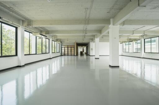 Spacious empty industrial-style room with large windows