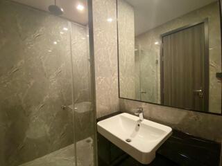 Modern bathroom with a large mirror and a walk-in shower