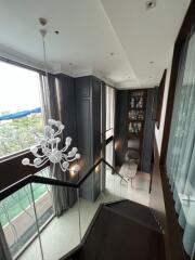 Elegant stairway with a modern chandelier and large windows