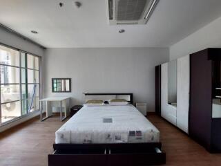 Spacious bedroom with large bed, wardrobe, air conditioning, and window