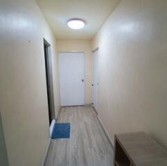 Well-lit hallway with wooden flooring