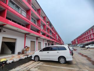 Exterior view of multi-story residential building with parking area