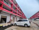 Exterior view of multi-story residential building with parking area