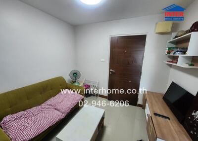 Cozy living room with a green sofa and a wooden door