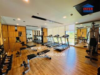 Well-equipped gym area with modern fitness machines and wooden flooring