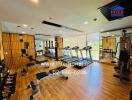 Well-equipped gym area with modern fitness machines and wooden flooring