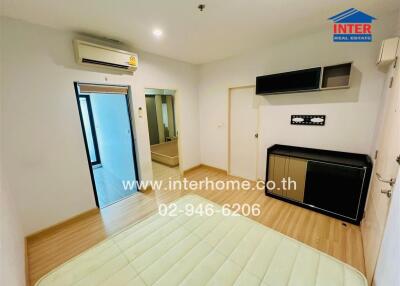 Bedroom with wooden flooring, built-in wardrobe, wall-mounted cabinets, and air conditioning