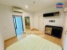 Bedroom with wooden flooring, built-in wardrobe, wall-mounted cabinets, and air conditioning