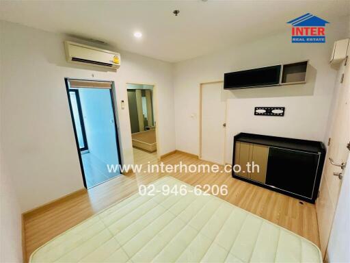 Bedroom with wooden flooring, built-in wardrobe, wall-mounted cabinets, and air conditioning