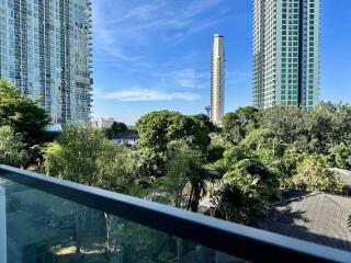 View from balcony overlooking greenery and skyscrapers