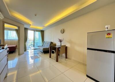 Modern living room with a sofa, dining table, and refrigerator