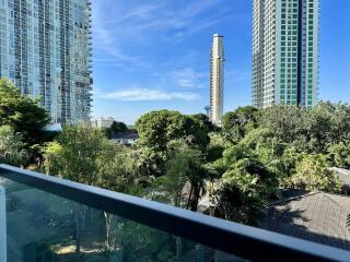 View from balcony overlooking trees and high-rise buildings
