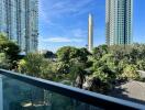 View from balcony overlooking trees and high-rise buildings