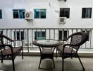 balcony with wicker furniture overlooking neighboring building