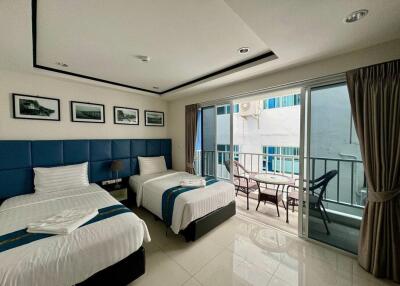 Bedroom with two single beds, balcony view, and modern decor