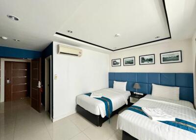 Modern bedroom with two beds, blue headboards, and wall art