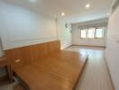 Spacious bedroom with wooden paneling and three windows